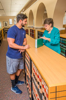 Professor Rebecca Trammell counsels a student in the library.