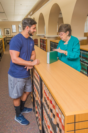 Professor Rebecca Trammell counsels a student in the library.